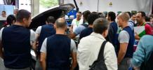 A imagem mostra várias formandos e alguns formadores a olhar para um automóvel com o capot aberto onde se mostra como é constituído atualmente um automóvel e com isso a evolução tecnológica no setor.